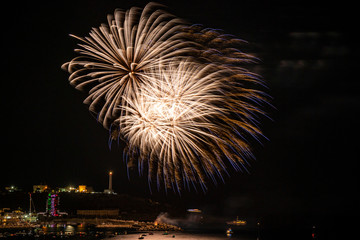 Beautiful fireworks in Santa Maria di Leuca, on the night of August 15th, in the summer holidays. Flashes of the colored fires are reflected on the sea. Boats watch the show. Puglia, Salento, Italy.