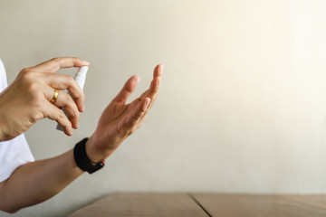 Health Care, Sanitary and Virus Germ Protection Concept. Close up of man hand holding and using a mini bottle of alcohol 70% spray to cleansing hand to protect Coronavirus with copy space.