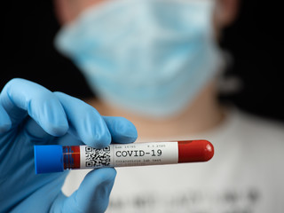 Test tube sample COVID-19 test in hand or researcher in rubber glove, yound researcher in the...