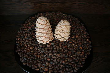 Pine nuts in shells as a background and two whole cedar cones