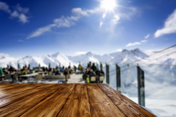 Wooden desk of free space for your decoration and blurred background of winter restaurant and landscape of muntains. 