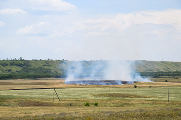 Fototapeta na wymiar Fire in field where hay was grown. burning dry grass