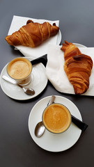 Glass Cups of Coffee with Fresh Croissants on a Black Table 