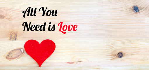 All You Need is Love Text with Red Heart on a Wooden Background