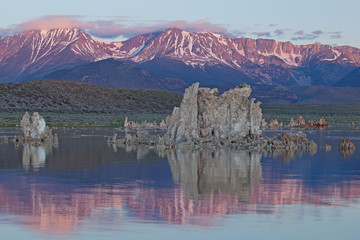 Sunrise, Mono Lake and Eastern Sierra Nevada Mountains with tufa formations and reflections in calm water, California, USA