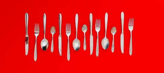 classic set of steel cutlery flat lay on the colorful background pattern design wide long banner