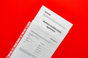 some sheets of paper documents flat lay in the plastic protection envelope on the table in office