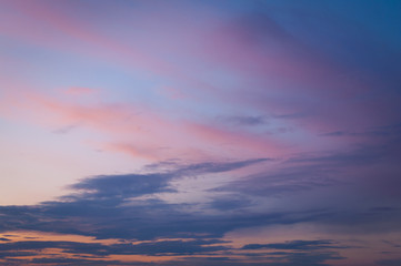 Naklejka na ściany i meble Colorful sunset sky over the horizon. Layered clouds.