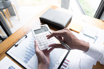 Businessman using calculator on the table in the office room