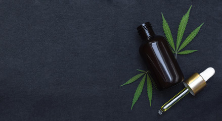 CBD oil or tincture make with cannabis on black background with copy space left. Medical marijuana...