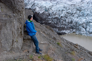 Hiker tourist looking at view Iceberg landscape with giant icebergs and lake. Arctic nature heavily affected by climate change, Global warming .