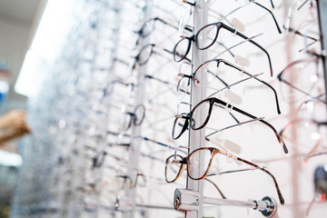 Image of a glasses showcase in a modern optic shop, selective focus.