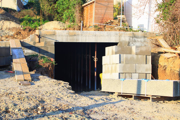 Founding a house. Raw wall without plaster and plaster, with a palette of concrete blocks next to it. Building materials.