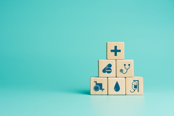 Health insurance concept, Wood blocks with healthcare medical icons on blue background, copy space - obrazy, fototapety, plakaty