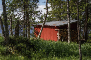 Red forest cottage on the shores of the lake, Svarta Sjöarn in Sweden