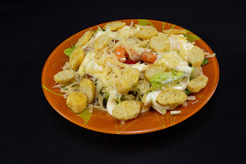 Caesar salad with shrimp on a black background.