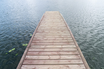 Wooden bridge for swimming on the shore of a lake. Blue water, summer nature landscape.  Environmental concept, Latvia, Europe.