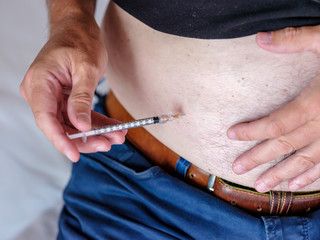 Person using a syringe to get an injection