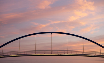 suspension bridge over the sea at sunset