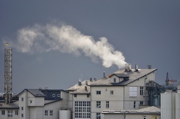 white smoke from a chimney against a cloudy sky