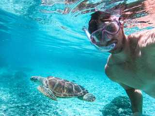 A man swimming with a sea turtle underwater