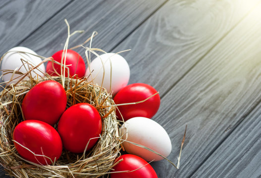 colored deep red Easter eggs in nest top view background, selective focus image. Happy Easter card