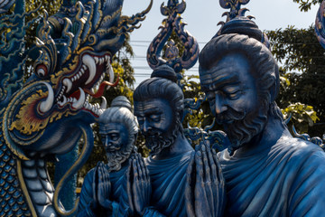 Fototapeta na wymiar Chiang Rai's Blue Temple statues. Three typical thai statues located in a buddhist temple