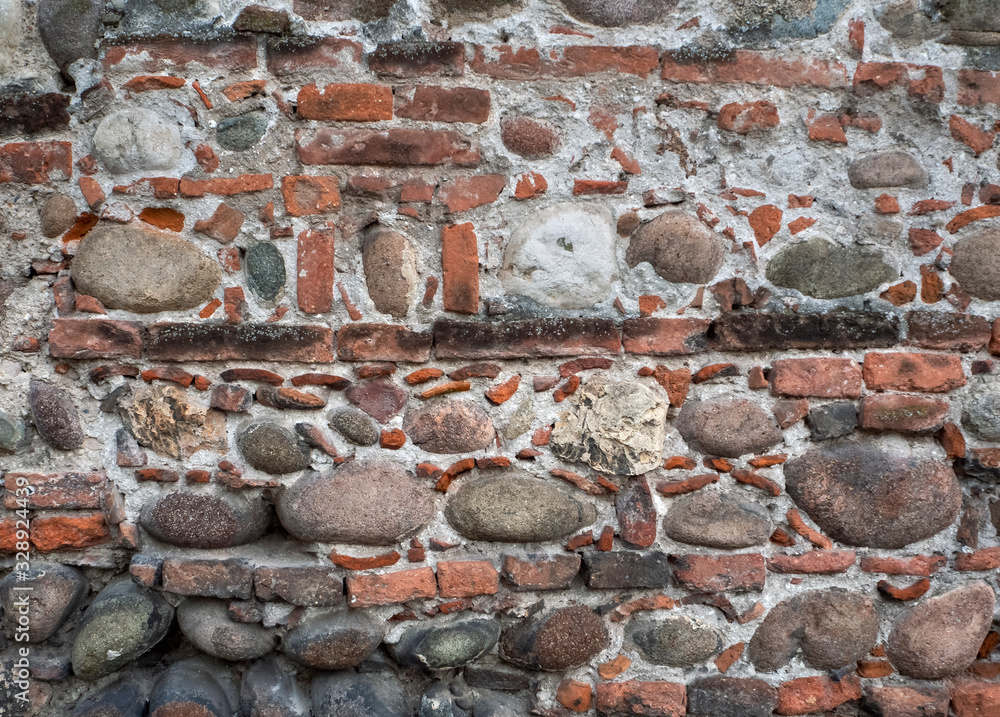 Poster the ancient wall is lined with bricks of various sizes and large cobblestones. bricks and cobbleston