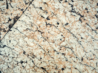 Light marble background with beige streaks and cracks closeup. Old stone background.