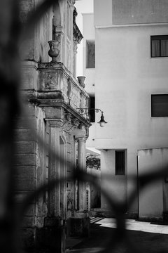 Facciata antico palazzo dietro cancello in bianco e nero