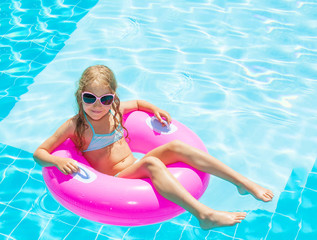 Girl on inflatable ring in swimming pool