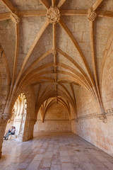 Tourist couple at the ornamental cloister at the historic Manueline style Mosteiro dos Jeronimos (Jeronimos Monastery) in Belem, Lisbon, Portugal.