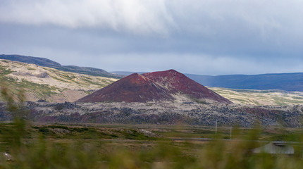 Krafla, Iceland volcanic landscape high angle view of road highway near lake Myvatn with colorful vibrant red mineral hill.