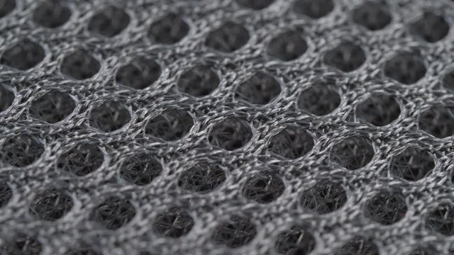 Textile background - gray polyester synthetic mesh fabric. Weave pattern of threads close up. Macro shoot