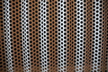 Background of black holes pattern and shades on a metal sheet
