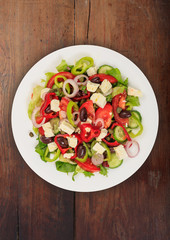 Greek salad with fresh vegetables and feta cheese background texture.