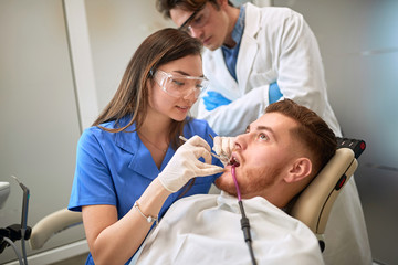 Obraz na płótnie Canvas Dentist repairing tooth to male patient