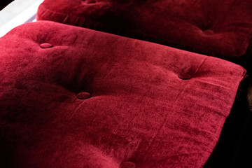Red velvet pillows on a bench closeup