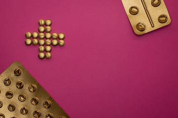 pills in cross shape and blisters on pink background - 328931233