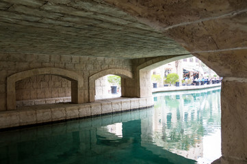 View under the bridge : stone arches over the river.