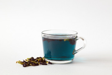 Hot drinks. Healthy lifestyle. butterfly pea tea. glass cup of blue herbal tea on a white background. cup of hot blue tea with dry flowers on a white table. copy space.