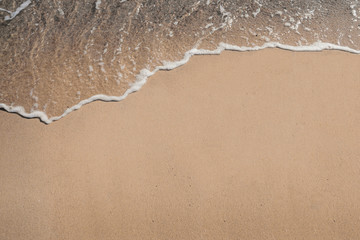 Soft ocean wave on sandy beach background. Holidays by the sea