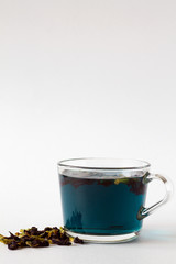 Healthy lifestyle. butterfly pea tea. glass cup of blue herbal tea on a white background. cup of hot blue tea with dry flowers on a white table. Hot drinks. copy space.