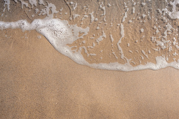 Soft blue ocean wave on clean sandy beach . Holidays by the sea