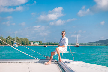 Seychelles, young men on vacation with sailing boat at the Seychelles tropical island