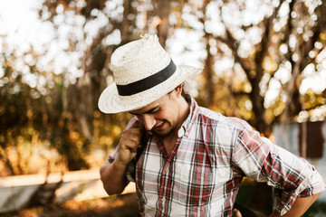 Obraz premium Young farmer gets ready to work in field with manual pump tank