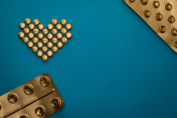 pills in heart shape and blisters on blue background - 328932087