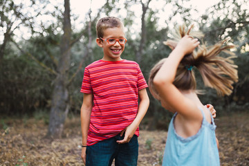 Two kids playing and dancing in the forest
