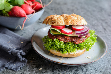 Vegetarian beetroot burger with Lollo Bionda lettuce, tartar sauce, red onion, zucchini and radish slices