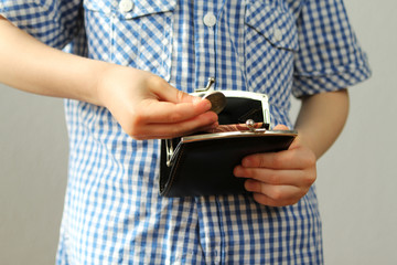 kid holds euro coins and black wallet in his hand, concept of pocket money, theft, shopping